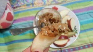 Fresh apple slices spread with almond butter and sprinkled with hemp seeds.