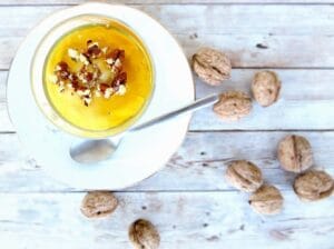 Creamy Greek yogurt topped with crushed walnuts and a drizzle of honey in a glass bowl.